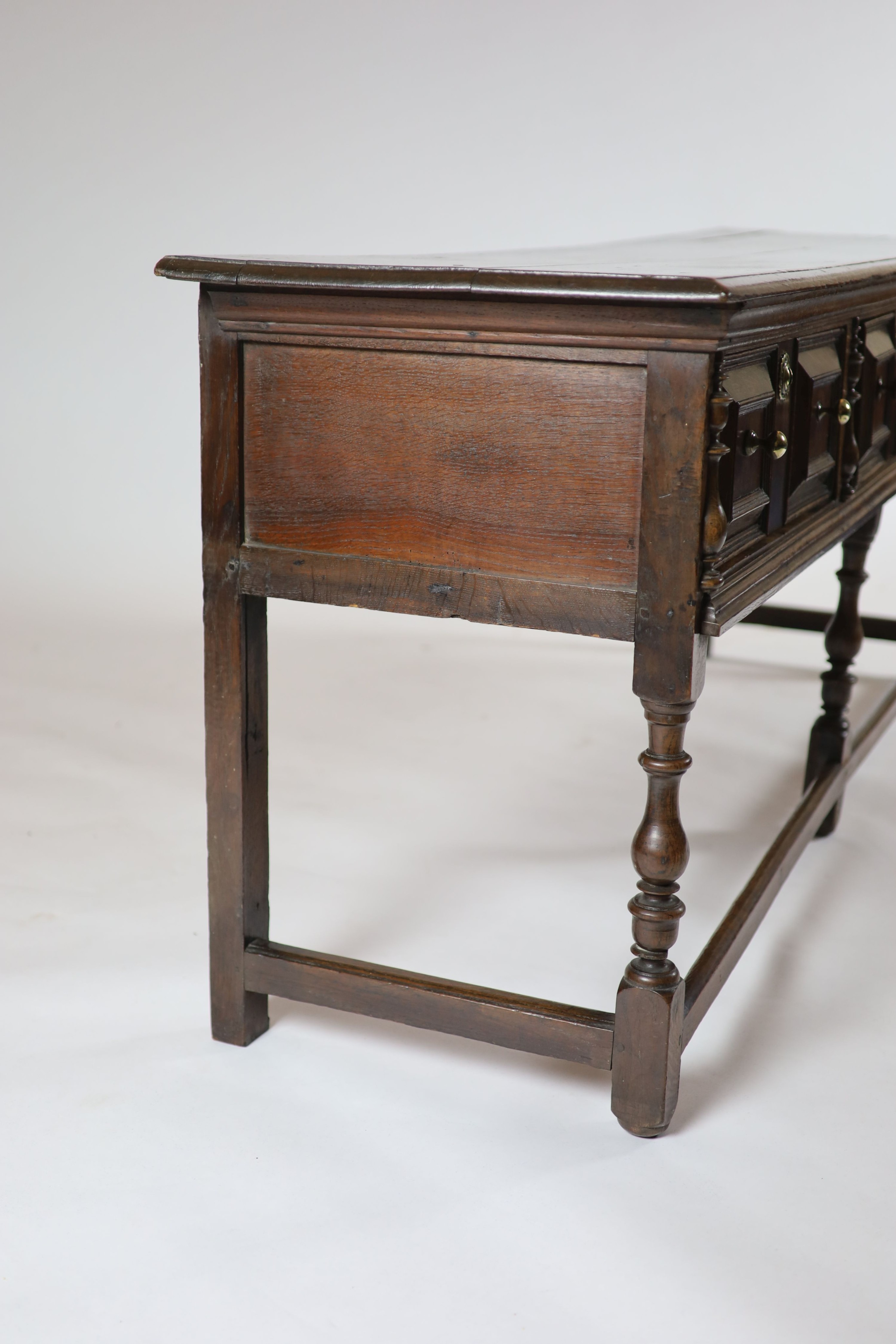 A late 17th century oak low dresser, H 81cm. W 205cm. D 54cm.